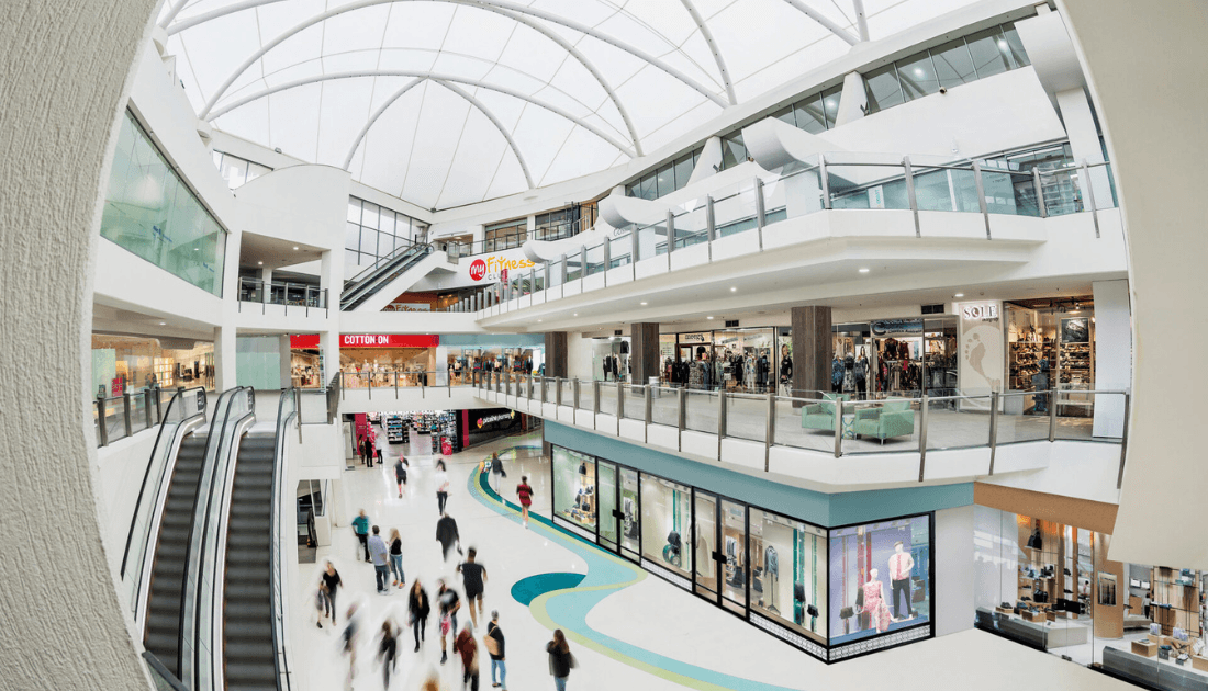 Inside The Oasis shopping centre, escalators and shopfronts
